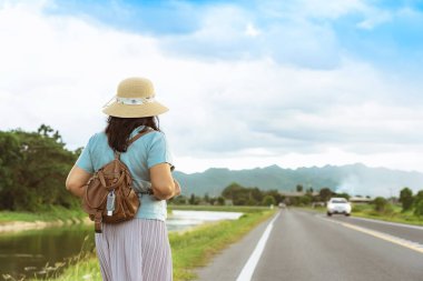 Corona Virüsü 'nü (Covid-19) öldürmek için mini taşınabilir alkol jeli şişesi açık yolda duran bir kadının deri omuz çantasına tutun. Yeni normal yaşam tarzı. Sağlık hizmeti kavramı. Alkol jeline odaklan.