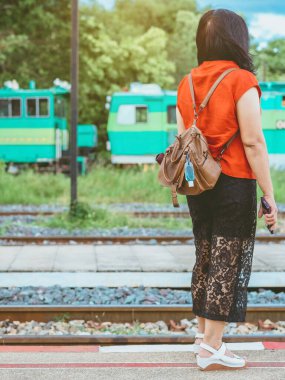 Corona Virüsü 'nü (Covid-19) öldürmek için mini taşınabilir alkol jeli şişesi demiryolu istasyonundaki kadının deri omuz çantasına asıldı. Yeni normal yaşam tarzı. Sağlık hizmeti konsepti. Alkol jeline odaklan