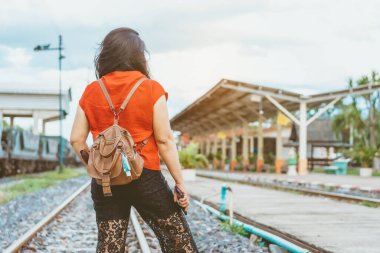Corona Virüsü 'nü (Covid-19) öldürmek için mini taşınabilir alkol jeli şişesi demiryolu istasyonundaki kadının deri omuz çantasına asıldı. Yeni normal yaşam tarzı. Sağlık hizmeti konsepti. Alkol jeline odaklan