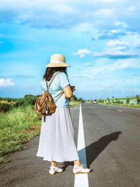 Corona Virüsü 'nü (Covid-19) öldürmek için mini taşınabilir alkol jeli şişesi açık yolda duran bir kadının deri omuz çantasına tutun. Yeni normal yaşam tarzı. Sağlık hizmeti kavramı. Alkol jeline odaklan.