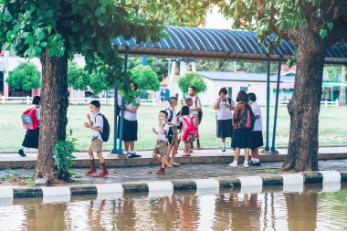 Kanchanaburi, Tayland-2 Temmuz 2020: Coronavirus 'un (Covid-19) okuldan sonra eve dönmesini engellemek için tanımlanamayan ilkokul öğrencileri maske takıyor ve KTR okulunda yağmur sadece duruyor.