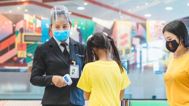 KANCHANABURI, THAILAND-11 Temmuz 2020: Güvenlik görevlisi, Robinson Mağazası girişinde Coronavirus 'u (Covid-19) önlemek için müşteriler için vücut termometresi ve alkol jeli enjeksiyon hizmetini kullanın