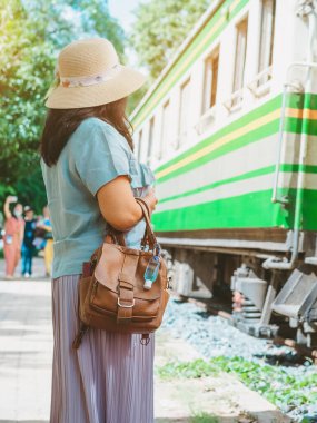 Corona Virüsü 'nü (Covid-19) öldürmek için mini taşınabilir alkol jeli şişesi demiryolu istasyonundaki kadının deri omuz çantasına asıldı. Yeni normal yaşam tarzı. Sağlık hizmeti konsepti. Alkol jeline odaklan