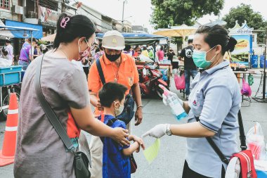KANCHANABURI, THAILAND-MAYIS 23,2020: Yerel pazarda Coronavirus 'un (Covid-19) yayılmasını önlemek için alışverişe çıkmadan önce QR kod veya kayıt defteri kullanılarak vücut sıcaklığının incelenmesi ve kimlik kaydı
