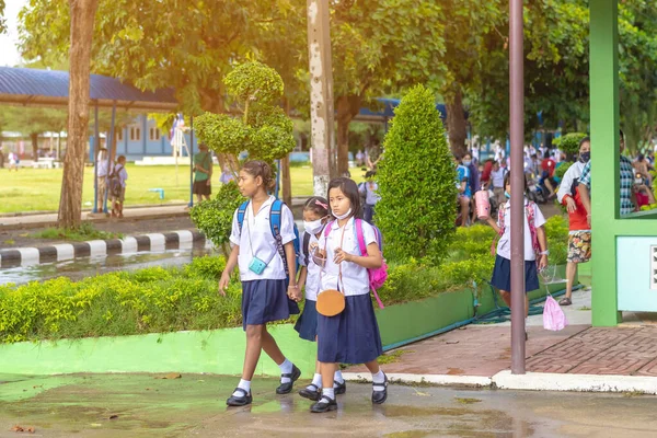 Kanchanaburi, Tayland-2 Temmuz 2020: Taylandlı öğrenciler okuldan sonra kendilerini Coronavirus 'tan (Covid-19) korumak ve KTR okulunda yağmur durduktan sonra evlerine dönmek için çeşitli tıbbi maskeler takıyorlar.