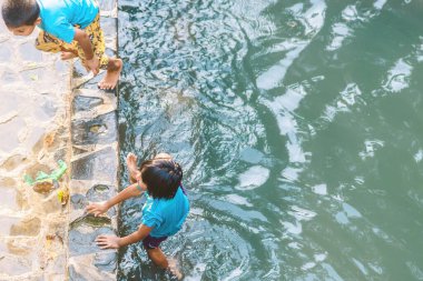 KANCHANABURI, THAILAND - 1 Ocak 2020 'de Kanchanaburi, Tayland' da kimliği belirlenemeyen Asyalı turistler cesedi sıcak maden suyuna batırıp sağlık için Hindad Hotspring 'te yıkandılar..