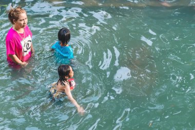 KANCHANABURI, THAILAND - 1 Ocak 2020 'de Kanchanaburi, Tayland' da kimliği belirlenemeyen Asyalı turistler cesedi sıcak maden suyuna batırıp sağlık için Hindad Hotspring 'te yıkandılar..