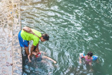 KANCHANABURI, THAILAND - 1 Ocak 2020 'de Kanchanaburi, Tayland' da kimliği belirlenemeyen Asyalı turistler cesedi sıcak maden suyuna batırıp sağlık için Hindad Hotspring 'te yıkandılar..