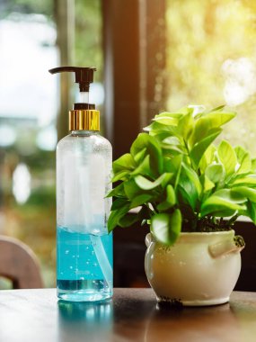 Coronavirus 'un (Covid-19) yayılmasını önlemek için el temizliği için mavi alkol jeli şişesi, kafedeki müşterilere hizmet için masaya konmuştur. Sağlık sigortası konsepti. Yeni normal yaşam tarzı