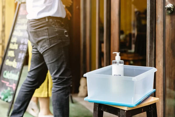 Alcohol gel bottle for hand cleaning to prevent the spreading of the Coronavirus (Covid-19)in a plastic box placed on chair to service for customers at cafe. Healthcare concept. New normal lifestyle