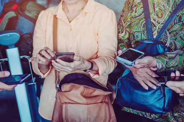 Elderly women learn how to use applications related to language translation from young men. While traveling abroad at the airport.