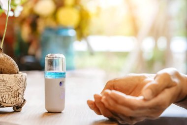 Corona virüsünün (Covid-19) müşterilere hizmet etmesini önlemek için el temizleme için alkol nano spreyi. Modern sağlık teknolojisi. Yeni normal yaşam tarzı. Seçici odak