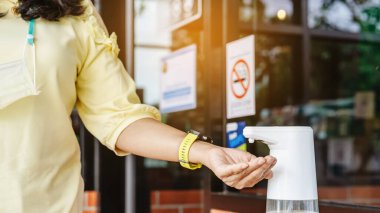 Coronavirus 'un (Covid-19) kafeteryaya girmeden önce masaya yayılmasını önlemek için otomatik alkol dağıtıcısı. Sağlık sigortası konsepti. Yeni normal yaşam tarzı. Seçici odak