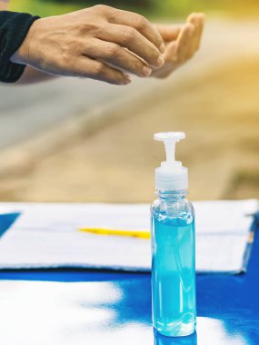 Mavi alkol jeli şişesi ve sporcuların Corona Virüsü (COVID -19) enfeksiyonunu önlemeleri ve halka açık alanda egzersiz yapmadan önce yayılması için masanın üzerinde bir kayıt defteri. Yeni normal yaşam tarzı. Seçici odak