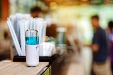 Corona virüsünün (Covid-19) müşterilere hizmet etmesini önlemek için el temizleme için alkol nano spreyi. Modern sağlık teknolojisi. Yeni normal yaşam tarzı. Seçici odak