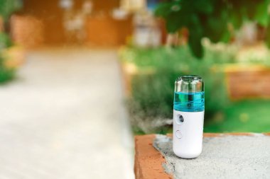 Corona virüsünün (Covid-19) bir kahve dükkanına yayılmasını önlemek için el temizleme için alkol nano spreyi. Modern sağlık teknolojisi. Yeni normal yaşam tarzı. Seçici odak