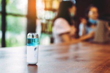 Corona virüsünün (Covid-19) müşterilere hizmet etmesini önlemek için el temizleme için alkol nano spreyi. Modern sağlık teknolojisi. Yeni normal yaşam tarzı. Seçici odak