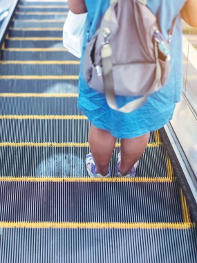 Coronavirus 'un alışveriş merkezindeki Covid-19 salgını sırasında sosyal mesafeyi korumak için yürüyen merdiven zemininde beyaz daireler sembolü uyarısı. Yeni normal yaşam tarzı