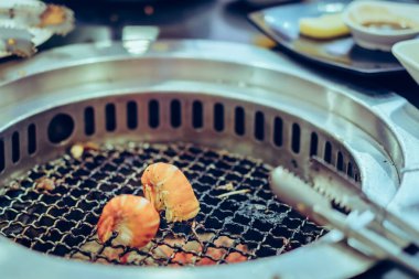 İnsanlar bir restoranda dumansız barbekü ızgara et ızgara. Karideslere seçici odaklanma.