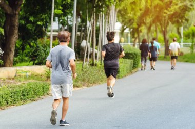 Spor salonundaki Asyalı yaşlı bir adamın arka plan portresi halka açık parkta yürüyüş ve sağlık için koşu yapıyor. Doğada kıdemli koşucu. Huzurlu doğanın tadını çıkaran yaşlı adam. Sağlık hizmetleri kavramı.