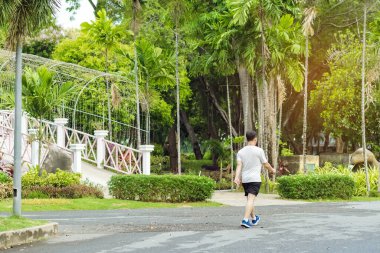 Spor salonundaki Asyalı bir adamın arka plan portresi halka açık parkta yürüyüş ve sağlık için koşu yapıyor. Doğada koşan biri. Huzurlu doğanın tadını çıkaran bir adam. Sağlık hizmetleri kavramı.