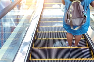 Coronavirus 'un alışveriş merkezindeki Covid-19 salgını sırasında sosyal mesafeyi korumak için yürüyen merdiven zemininde beyaz daireler sembolü uyarısı. Yeni normal yaşam tarzı