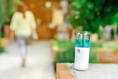 Corona virüsünün (Covid-19) bir kahve dükkanına yayılmasını önlemek için el temizleme için alkol nano spreyi. Modern sağlık teknolojisi. Yeni normal yaşam tarzı. Seçici odak