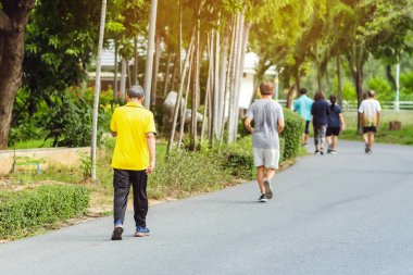 Spor salonundaki Asyalı yaşlı bir adamın arka plan portresi halka açık parkta yürüyüş ve sağlık için koşu yapıyor. Doğada kıdemli koşucu. Huzurlu doğanın tadını çıkaran yaşlı adam. Sağlık hizmetleri kavramı.