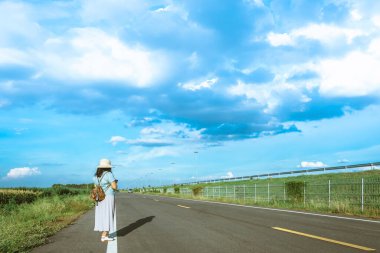 Corona Virüsü 'nü (Covid-19) öldürmek için mini taşınabilir alkol jeli şişesi açık yolda duran bir kadının deri omuz çantasına tutun. Yeni normal yaşam tarzı. Sağlık hizmeti kavramı. Alkol jeline odaklan.