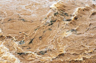 Kirli su bol bol akar. Nehir suyu bol bol akıyor. Sel suları, fırtına üstüne sel gibi akıyor. Çalkantılı nehir barajı. Baraj nedeniyle nehir türbülansı. Su Doğa DokusuName