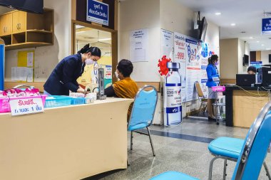 BANGKOK, THAILAND - 12 Mart 2022: Aşılanmış kişilerin güvenliği için COVID-19 aşısını hastanedeki hemşireler veya sağlık personeli almadan önce kontrol ve tansiyon ölçümü.