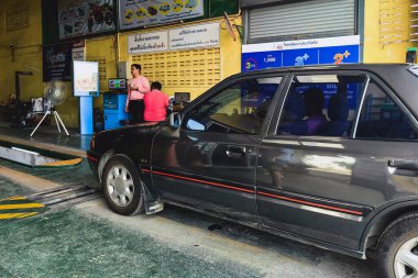 KANCHANABURI, THAILAND-EPTEMBER 3. 2024: Araç denetim tesisinde yıllık araç vergisi ödemeleri için araç denetim sertimine eski Mazda araba denetimi. Eski arabanın durumunu kontrol et..