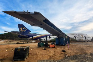 KANCHANABURI, THAILAND-APRIL 6. 2025: Tayland Havayolları 'ndan gelen eski bir ticari uçakla dağlarla çevrili yeni ve güzel bir yer için yapılan yenileme çalışmalarına bakın..