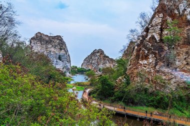 RATCHABURI, THAILAND-MAY 12.2019: Khao Ngu Taş Parkı 'ndaki Yılan Dağı olarak da bilinen taş sıradağları ile güzel doğa manzarasını ziyaret etmeye gelen tanımlanamayan turistler. Şaşırtıcı doğa..