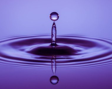 Bir parlak şeffaf mor waterdrop, su yüzeyinde bir yansıması ile sakin ve yumuşak bir görüntüsünü.