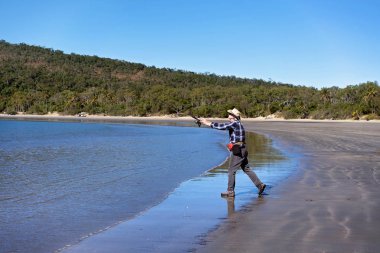 Sahilde balık tutma sırasında onun çubuk döküm emekli