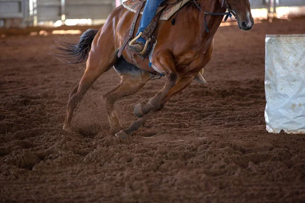 Close up of horse and rider kicking up dirt while barrel racing at a country rodeo in Australia