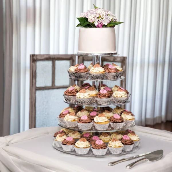 Tiers of cupcakes topped with a wedding cake