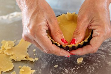 Shortcrust pasta pişirme için hazır tart bir teneke dolup eller