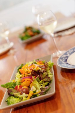 Öğle yemeği için kurmak ahşap bir masa üzerinde taze yeşil salata