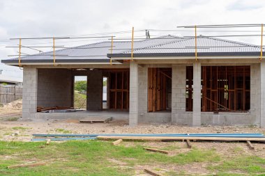 Siyah çelik çatılı bir Avustralya taşra kasabasında beton blok inşa ediliyor bir konut ev