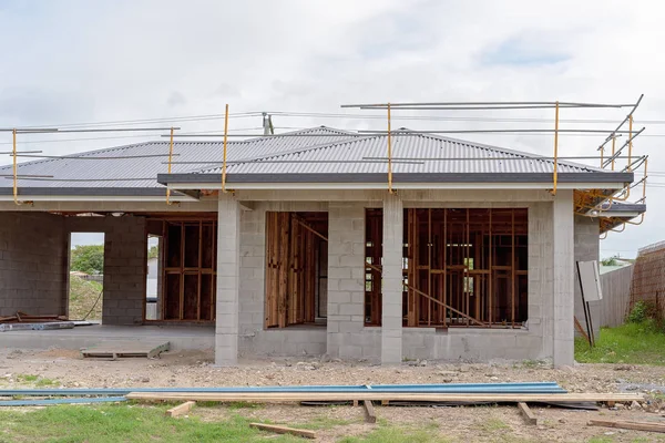 Front exterior of a block brick home being built in suburbia