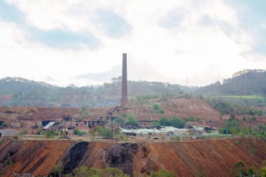 Terk edilmiş binalar ve baca yığın kapalı, bakıma muhtaç hale düşen Mount Morgan altın madeni efendim