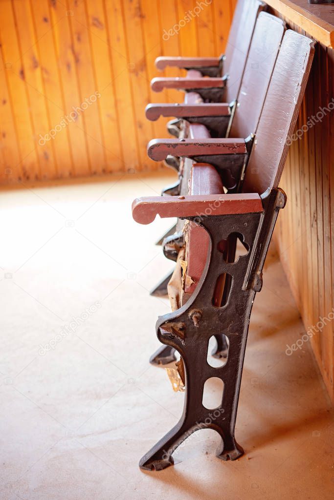 Row of vintage fold up chairs against a timber wall