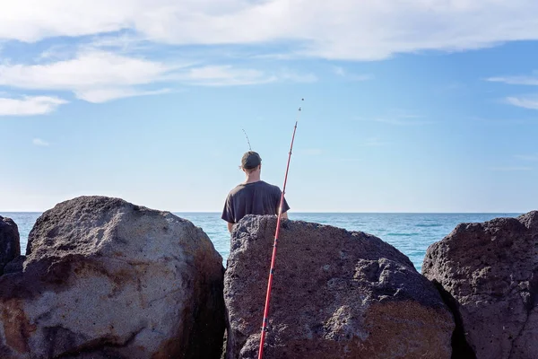 Fisherman Casting Rod Off Breakwater Rocks — Stock Photo, Image