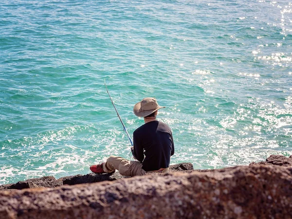 Retiree Male Fishing From Breakwater Rocks — Stock Photo, Image