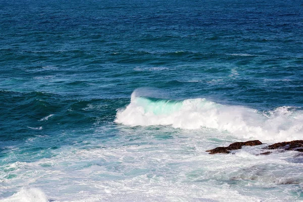 Meerwasser turbulent um Felsen — Stockfoto