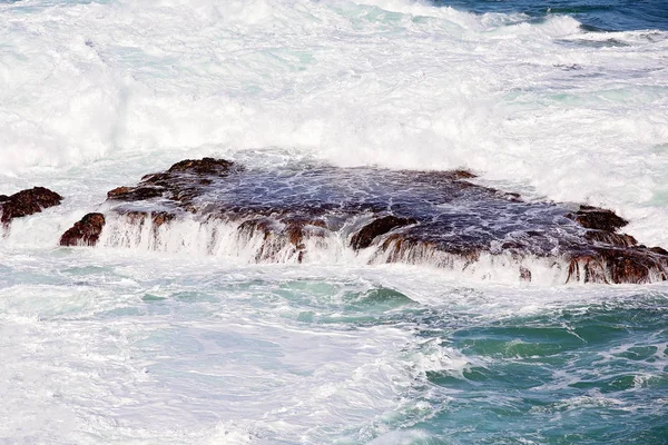 Onde oceaniche contro rocce — Foto Stock