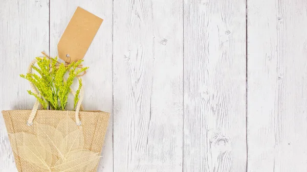 Foliage в гессіанській сумці з подарунковою міткою — стокове фото