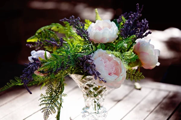 Disposizione vaso di fiori su un tavolo illuminato dal sole — Foto Stock